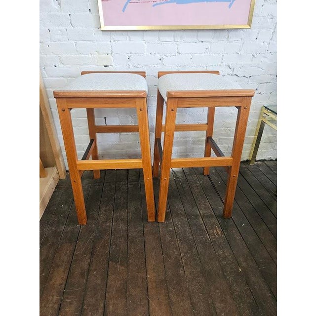 Pair of Danish Modern stools designed by J.L. Møller of Denmark. These stools have teak frames and are freshly...