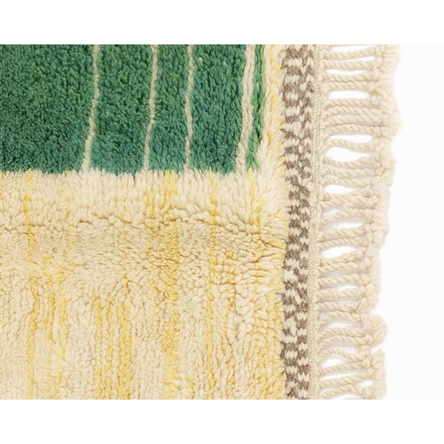 An ivory field scattered with story — architecture, color, and mark-making in quiet conversation. This hand-knotted wool...