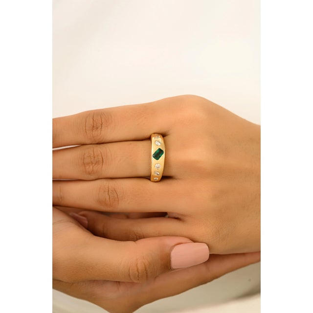 Crafted in 18k yellow gold, this unisex dome ring features a 0.31 carat emerald cut natural emerald and 0.31 carats of...