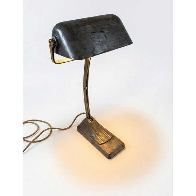 Elevate your workspace with a piece of French industrial history. This authentic desk lamp was manufactured by NIAM...