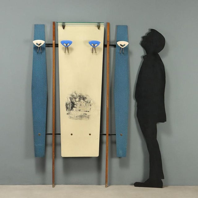 Wall-mounted coat rack from the 1960s, featuring a vintage design that combines functionality and style. The structure is...