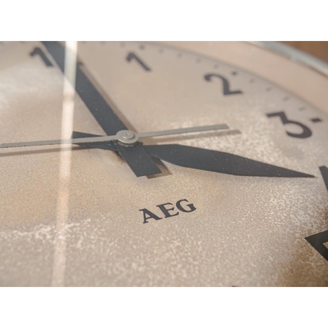 A wall clock by aeg in its original retro green paint, never repainted. The body and the cream dial have developed a deep,...