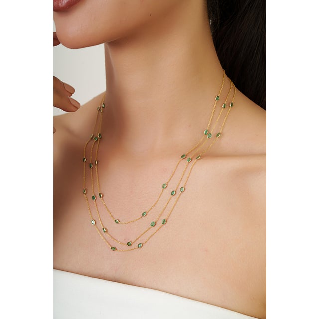 This elegant multi-strand necklace features 5.15 carats of emeralds set in 14K yellow gold. Each emerald measuring...