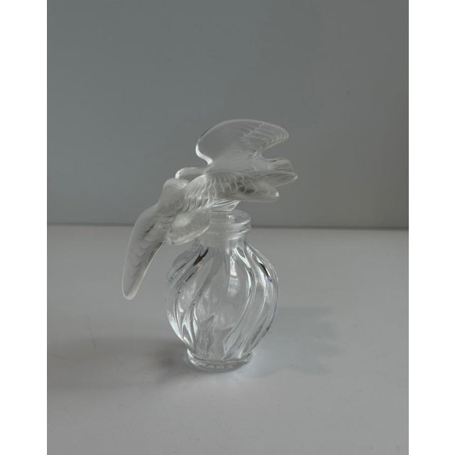 An iconic French crystal perfume bottle created by Lalique France for Nina Ricci’s legendary L’Air du Temps fragrance....