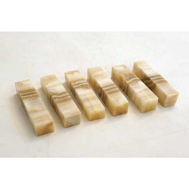 Set of 6 parallelepiped-shaped knife rests with beveled edges; all in solid veined ochre onyx stone