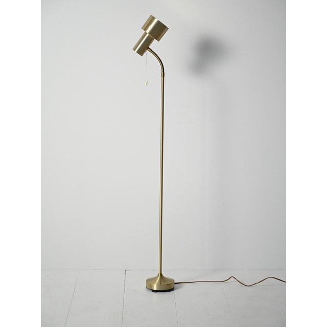 Floor lamp in gold-plated metal, elegantly curved stem, adjustable head on a gooseneck flexible hose. Clean lines with a...
