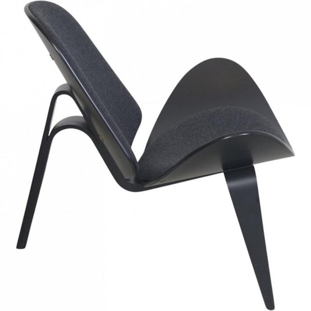Hans Wegner CH07 Shell chair upholstered in grey fabric and with a grey painted shell. The chair is from the 2010s and...