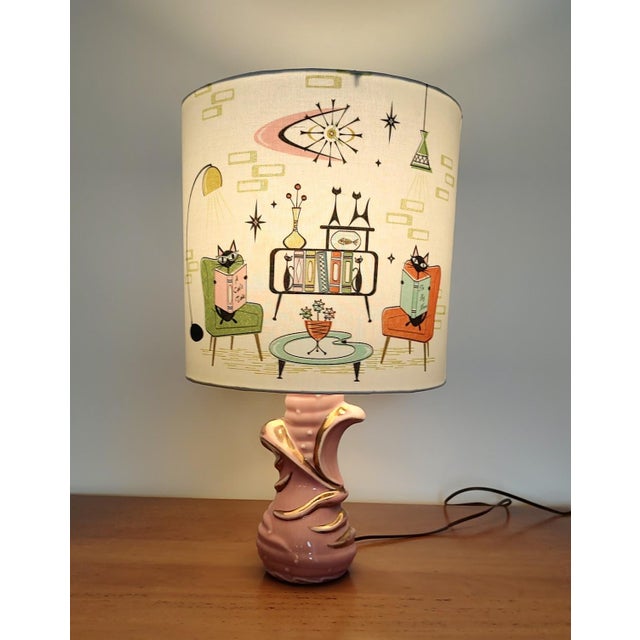 Super cute atomic cat lampshade with vintage C. Miller pink ceramic table lamp. The maker's mark on the back identifies...