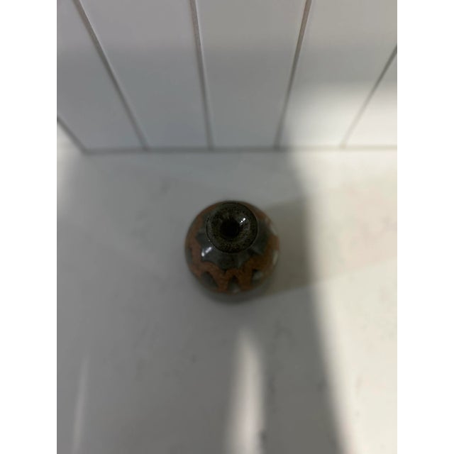 Handcrafted vintage pottery ceramic vase with a rounded body and a narrow neck. This piece seems to have been influenced...