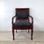Commanding and deeply elegant, this antique Empire style armchair is a statement piece for the ages. The rich dark...