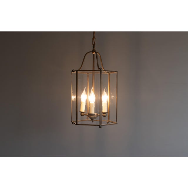 Glazed six panel brass framed three light lantern. Re-wired and tested. Circa 1930. Up to 250V (Europe/UK Standard).The...