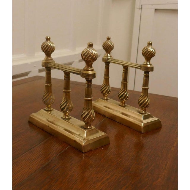 A heavy pair of Victorian brass fire dogs or fire dogs This very attractive pair of brass Fire Dogs is 9” high, 9” long...