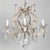 A set of two vintage Maria Theresa style five-light crystal chandeliers. Each with curving, ornate gilt metal frame clad...