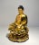 Vintage gold gilt cast resin sculpture of a seated buddha on a lotus flower, with a red Manji symbol. This sculpture has a...