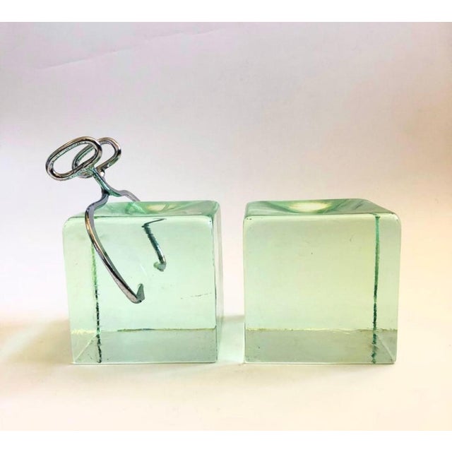 Pair of rare MCM ice block bookends by Curtis Jere. Made of heavy glass with 1 metal chrome tong The cubes measure 5” With...