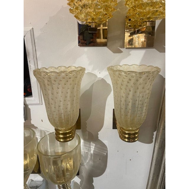 The product is a pair of Murano gold vase form sconces. These fixtures are crafted with a unique Murano glass design and a...