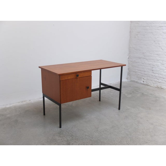 Nice minimalist desk in the style of Pierre Guariche produced in Belgium around 1960. Made of teak combined with a black...