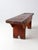 This early 20th century primitive bench features a grounded, utilitarian form with notched ends, exposed joinery, and a...