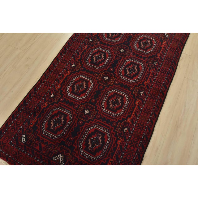 An authentic vintage tribal Baloch rug hand-knotted with fine wool and natural dyes. This nomadic oriental rug features...