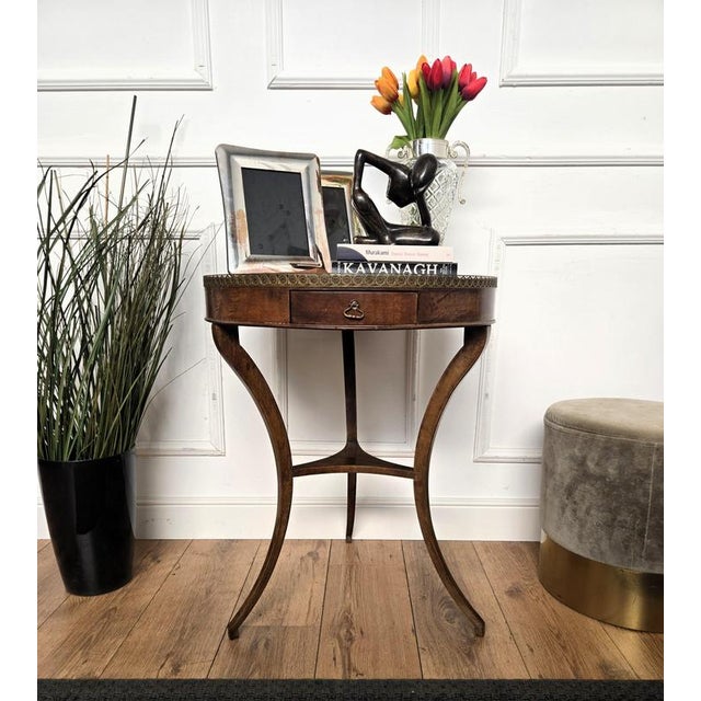Beautiful antique Italian solid walnut side table or console table features a round top with brass frame over a central...