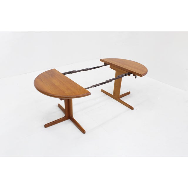 Vintage Danish round extendable dining table from the 1960s made of solid teak wood. This Danish dining table can be...