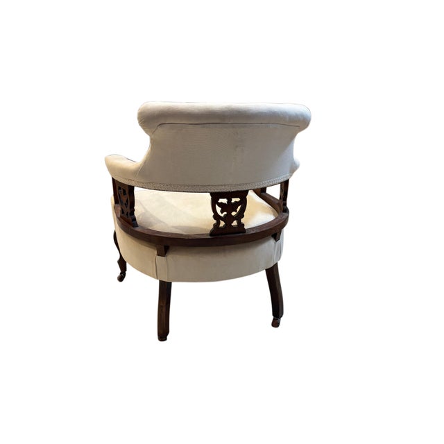 A handsome Regency-style library armchair crafted in rich mahogany and upholstered in a neutral cream fabric. This elegant...