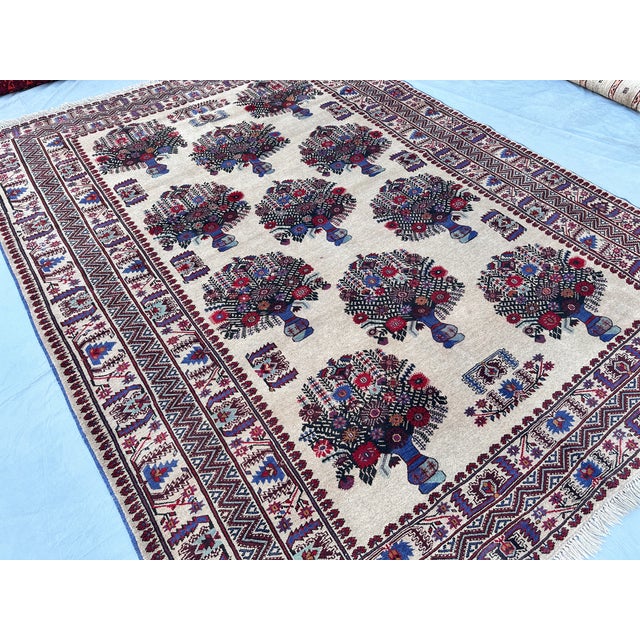 This charming rug features the classical vase design: a grid of stylized urns brimming with flowering bouquets in navy,...
