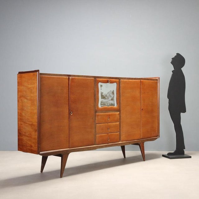 Italian-made sideboard dating back to the 1950s and 1960s, crafted from wood with a mahogany veneer. Featuring hinged...