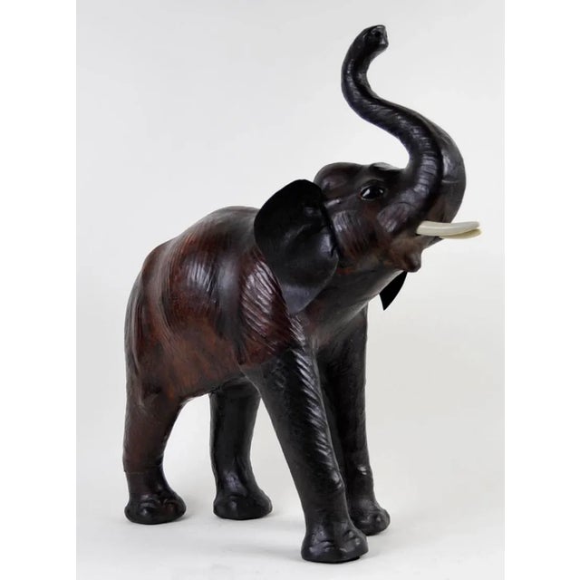 An extraordinary mammoth leather wrapped work of art, this tusked and glass-eyed elephant statue brings safari style to...