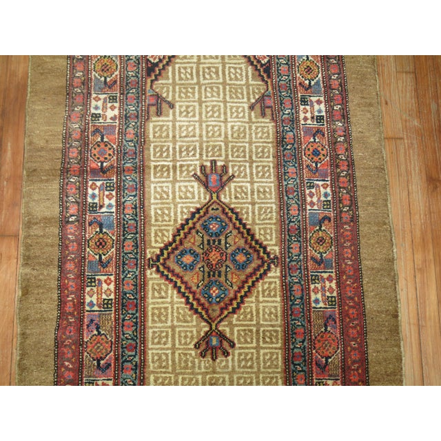An authentic early 20th century Persian Serab runner with 2 geometric medallions on a camel field and multi-band border in...