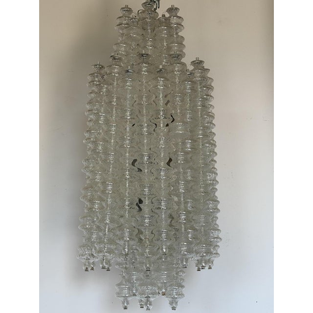 Large chandelier with cascading pendants in the shape of a spinning top, designed and produced by the Murano company...