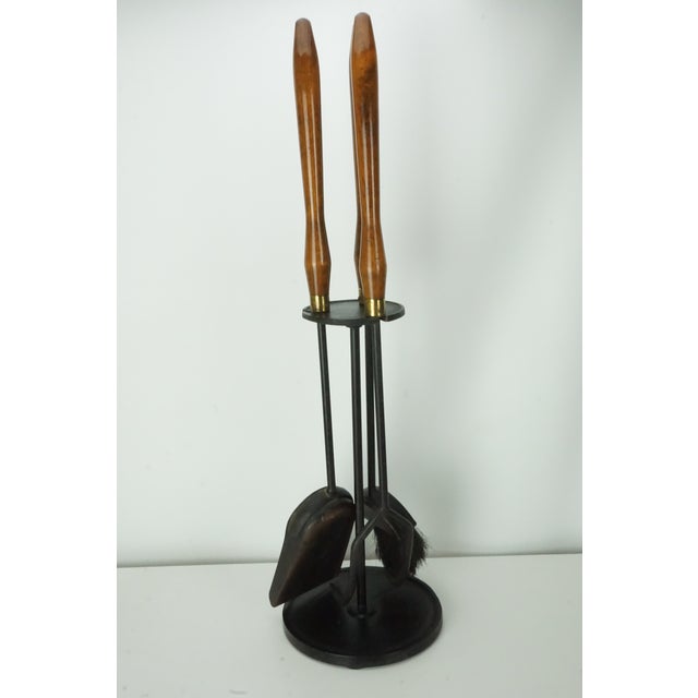 Beautiful vintage Mid-Century Modern fireplace tool set featuring long sculpted wood handles, brass collars, and black...