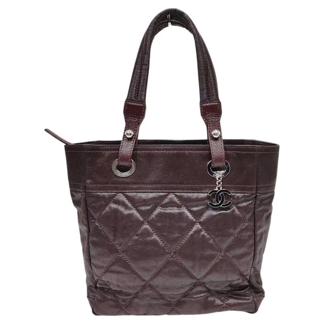 This sophisticated Chanel tote bag is crafted from a unique dark chocolate brown coated canvas, offering a subtle metallic...