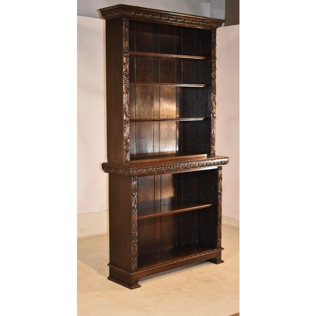 19th century oak tall carved bookcase from England. At the top, there is a stately crown molding with carving as well for...
