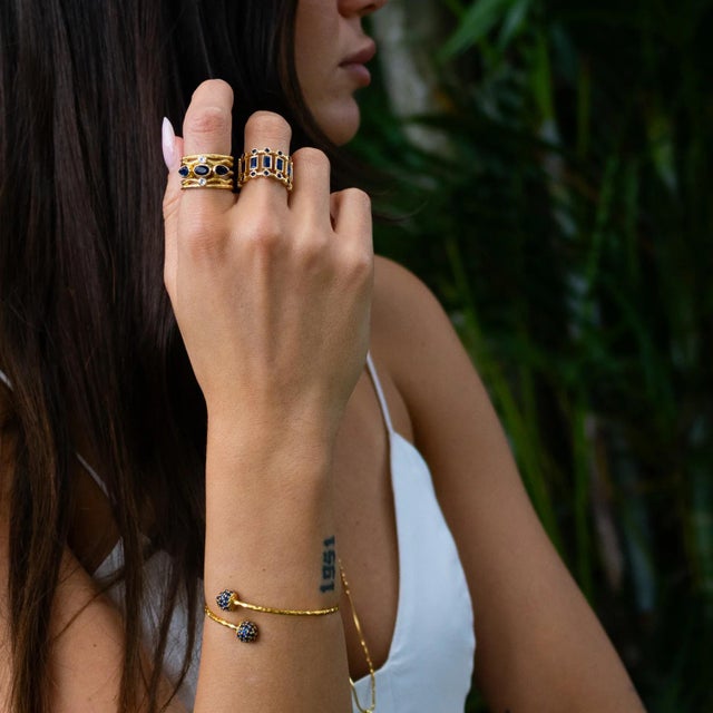 Bring a touch of mystique to your style with the Sapphire Grace Adjustable Gold Cuff Bracelet. Crafted from bronze with...