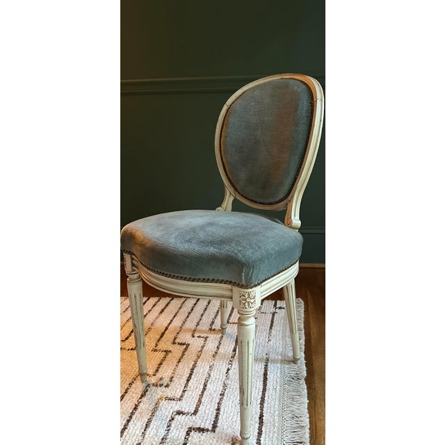 Perfectly aged French, Louis XVI balloon back chairs with fluted legs, square seats and a creamy distressed painted...