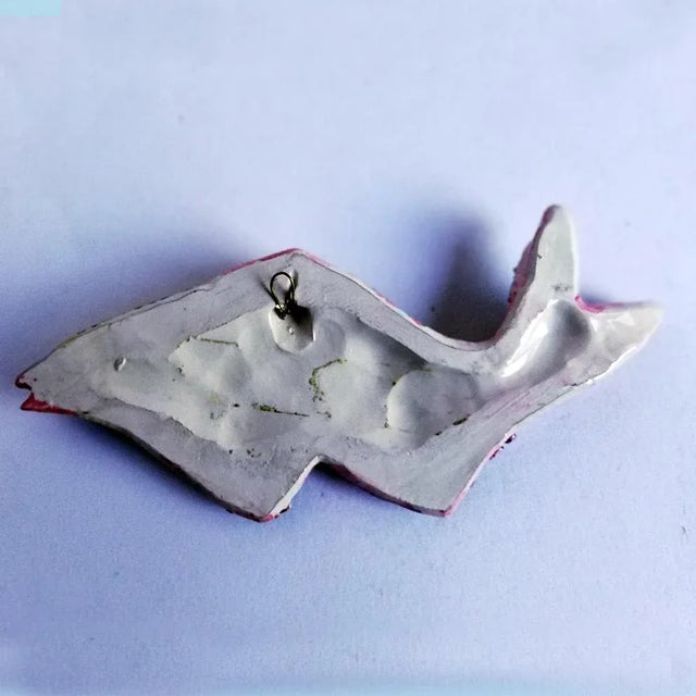 This fish sculpture is made of ceramic with polychrome enamels. It is signed Albisola.