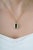 This halo pendant showcases a striking 5.5 carat emerald-cut green tourmaline, set in 14K yellow gold. The tourmaline...