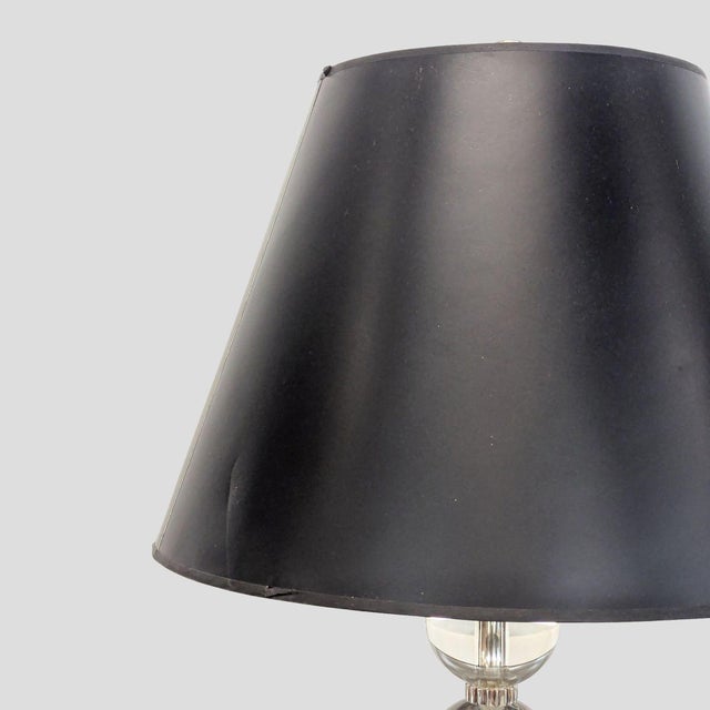 This stylish table lamp features a black lampshade and a unique base made of stacked clear glass spheres. Its sleek design...