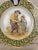 A good 19th century French Porquier Beau Quimper Plate with a green border depicting a man with a your child sharpening a...