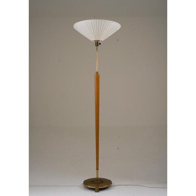 Swedish floor lamp from the 1940s with a combination of elm and brass. The slender, fluted rod in elm is complemented by...