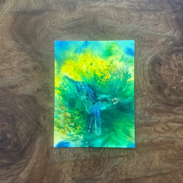 A luminous depiction of a hummingbird emerging from a vivid burst of green and yellow foliage. The background’s dynamic...