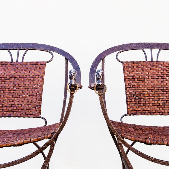 A striking pair of late 20th century equestrian motif accent chairs crafted from wrought iron and woven leather. The...