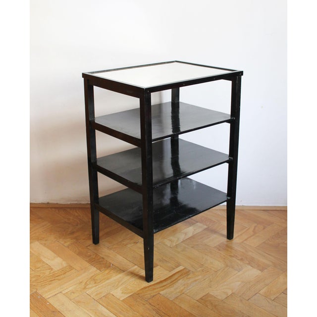A refined late 1940s Czechoslovak Modernist étagère or occasional table, constructed from slender black-painted timber...