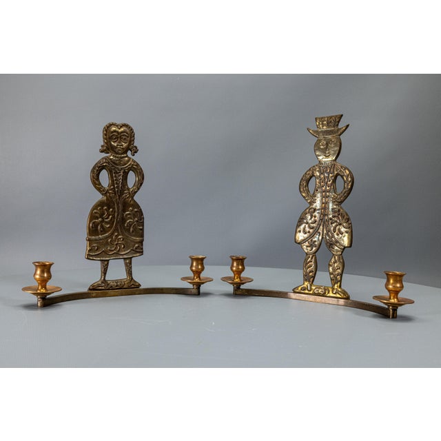 Decorative Scandinavian brass wall candle holders with stylized male and female folk figures, Denmark, 1970s. Decorative...
