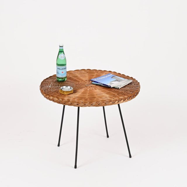 Charming and highly decorative Mid-Century round coffee table in hand-woven rattan wicker and black enameled iron. This...