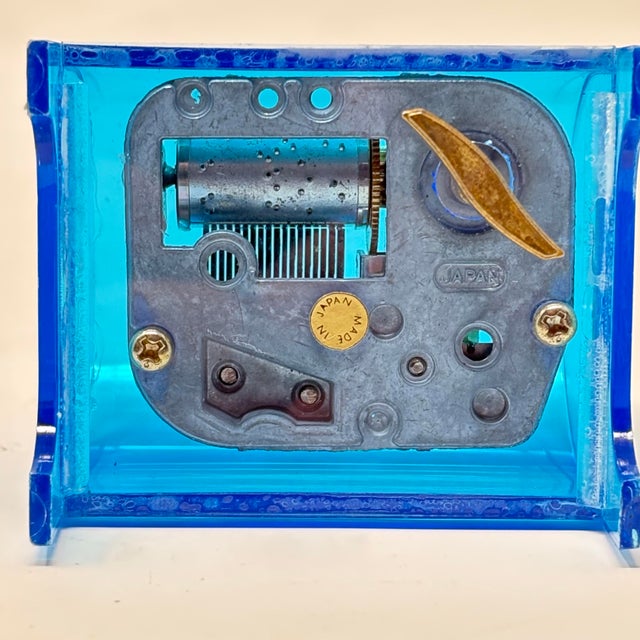 A vintage blue acrylic music box, which plays a portion of “Dance of the Sugarplum Fairy” from The Nutcracker. It has a...