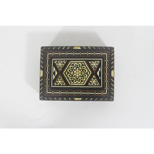 Lovely wood trinket box inlaid with an intricate pattern of different woods and bone. The hinged lid opens easily. Good...