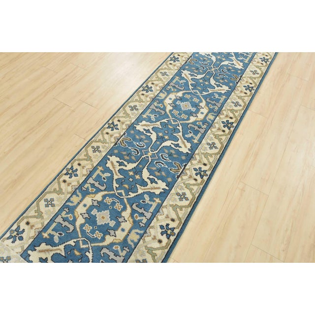 A modern tribal Oushak runner hand-knotted with an all-wool pile on a cotton foundation. This oriental rug features a...