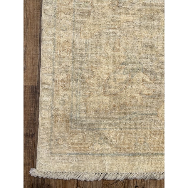 A stunning vintage Oushak area rug. This Oushak offers a neutral beige palette with soft blue and tan accents.
